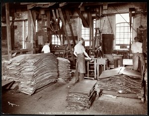 Interior view of three men working with leather and heavy equipment at the New York Leather Belting Co., New York, 1905 (silver gelatin print)